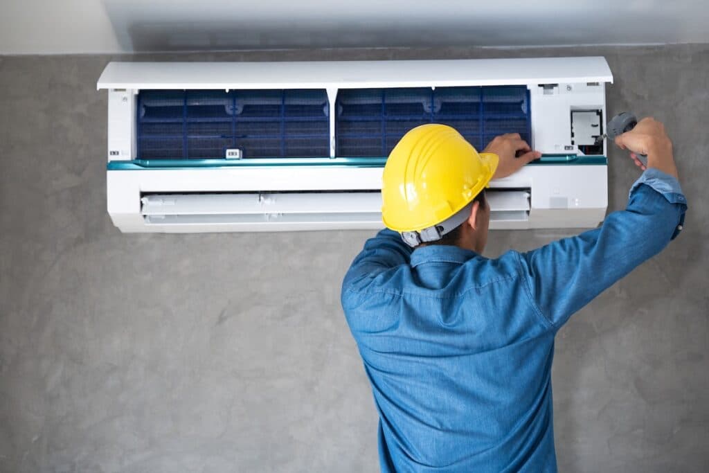 Cesar HVAC technician servicing a wall-mounted indoor unit